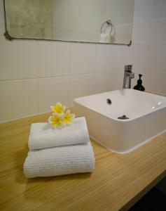 飞鱼湾Rumah Biru的一间带水槽和桌子毛巾的浴室