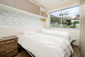 弗洛里亚诺波利斯SDF - Apartamentos lindos em Floripa-SC的配有2张床的小卧室设有窗户