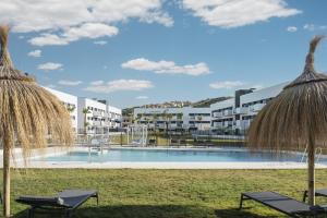 阿尔马亚特巴瑶Residencial Celere Playa Niza的一张带两把椅子的度假村游泳池的图片