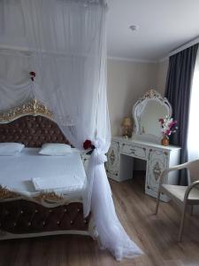 库斯塔奈Hotel Дар-Ай的白色卧室配有一张带天蓬的床