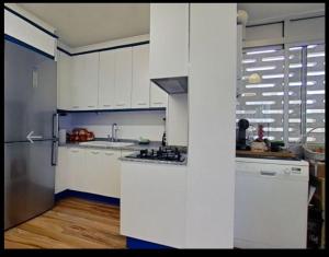 贝尼卡西姆Apartamento con piscina y cerca de la playa的厨房配有白色橱柜和不锈钢冰箱