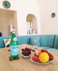 卡特瑞杜斯Dream Home- Santorini Cave House的坐在桌子上的一瓶雪碧,有一碗水果