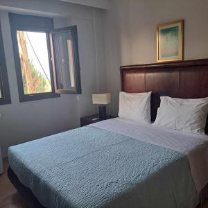 卡尼奥提Apartment beside the sea的一间卧室配有一张带蓝色棉被的床和窗户。