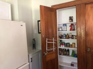 罗切斯特Seabreeze Three Bedroom Home的厨房设有开放式的食品室门和冰箱。