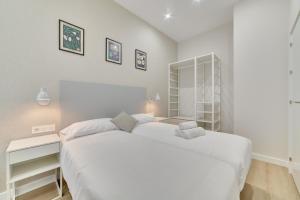 潘普洛纳Apartamento Pamplona Prime by Clabao的白色卧室配有一张大床和一张书桌