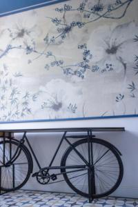 科奥恩Locanda alla Grotta的一辆自行车停在墙上,墙上挂着一幅画