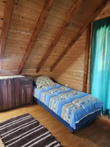 普卢日内Planinska tišina Guest House的木天花板的客房内的一张床位