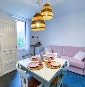 科奥恩Locanda alla Grotta的一间带桌子和粉红色沙发的用餐室