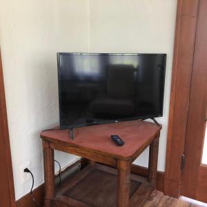 罗切斯特Seabreeze Three Bedroom Home的遥控器的木桌上的电视