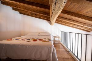 圣斯特凡诺·迪塞斯Cuore Nero Food and Relax的卧室配有白色的床铺和木制天花板