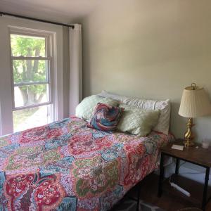 罗切斯特Seabreeze Three Bedroom Home的一间卧室配有一张带枕头和窗户的床