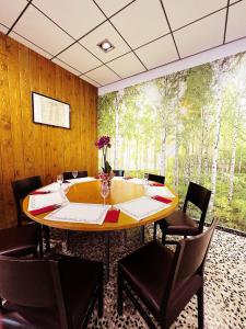 FuentespaldaFonda Aparicio的用餐室配有桌椅和森林壁画