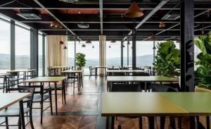 莫托文Winery & Design hotel ROXANICH的餐厅设有桌椅和大窗户。