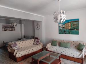 尼亚米卡尼奥纳Ki & Ki apartment 2, New Michaniona的客厅配有两张沙发和一个吊灯。