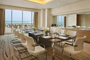 迪拜迪拜朱美拉海滩希尔顿逸林酒店的一间会议室,配有长桌和白色椅子