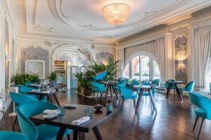 爱丁堡The Caledonian Edinburgh, Curio Collection by Hilton的餐厅设有蓝色的桌椅和天花板