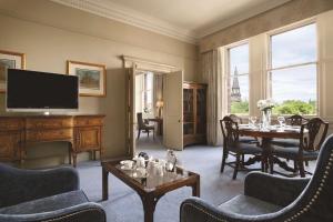 爱丁堡爱丁堡 - 喀里多尼亚华尔道夫酒店的客厅配有桌子和电视