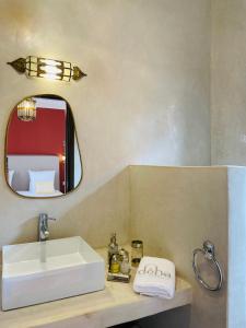 马拉喀什Riad Deha & Spa的浴室设有白色水槽和镜子
