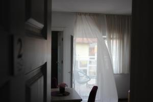 莫斯塔尔无限旅馆的客房设有带白色窗帘和桌子的窗户。