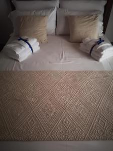 西尼斯科拉Domo Dizósa的一张带白色枕头的床和毛巾