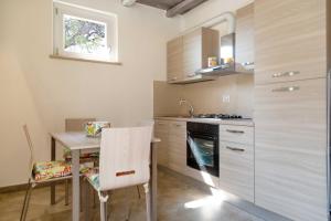 格罗塞托港Dimora La Fiumara的厨房配有小桌子和炉灶。