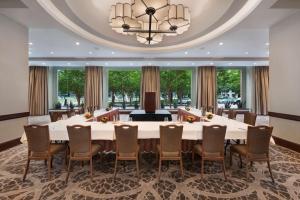 休斯顿休斯敦波斯特奥克希尔顿广场酒店 的大型会议室,配有大桌子和椅子