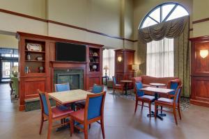 印第安纳波利斯印第安纳波利斯机场汉普顿套房酒店的客厅配有桌椅和壁炉