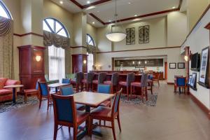 印第安纳波利斯印第安纳波利斯机场汉普顿套房酒店的一间带桌椅的餐厅和一间酒吧