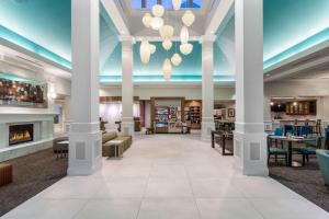 朗康科马艾斯利普/麦克阿瑟机场希尔顿花园旅馆的酒店大堂设有圆柱和壁炉