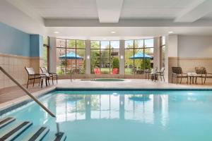 斯托尼布鲁克石溪希尔顿花园酒店的游泳池设有桌椅和窗户