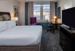 杰克逊杰克逊市区希尔顿花园旅馆的酒店客房配有一张床、一张书桌和一台电视。