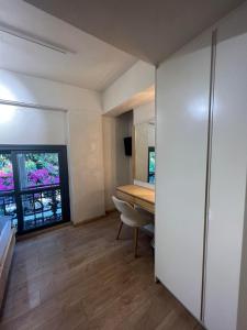 卡拉马塔Panellinion Luxury Rooms的小房间设有书桌和窗户