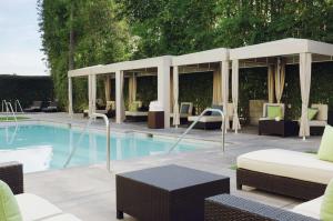 蒙罗维亚蒙罗维亚希尔顿逸林酒店 - 帕萨迪纳区的一座带桌椅的游泳池位于酒店大楼旁