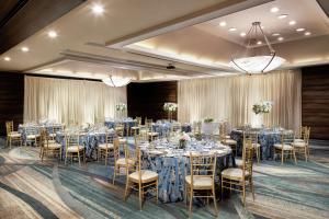 蒙罗维亚蒙罗维亚希尔顿逸林酒店 - 帕萨迪纳区的一个带桌椅和蓝色床单的宴会厅