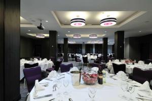 伦敦伦敦西区希尔顿逸林酒店的一间设有白色桌子和紫色椅子的用餐室