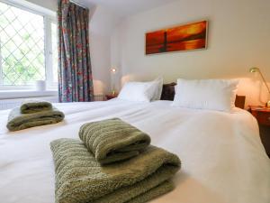 海斯廷斯Oak Meadow的卧室配有白色床和毛巾
