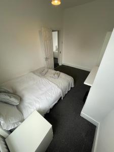豪士罗House by Araminta的卧室配有白色的床和桌子