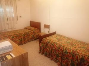 廖卢纳托Appartamento Riolunato (MO)的酒店客房设有两张床和一张桌子。