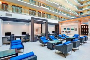 迈阿密迈阿密国际机场大使套房希尔顿酒店的一间设有蓝色椅子和桌子的等候室