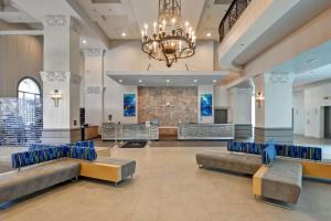 迈阿密迈阿密国际机场大使套房希尔顿酒店的一个带沙发和吊灯的大堂