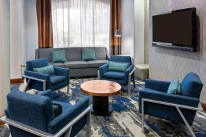 堪萨斯城乡村俱乐部广场汉普顿套房酒店的客厅配有沙发、椅子和电视