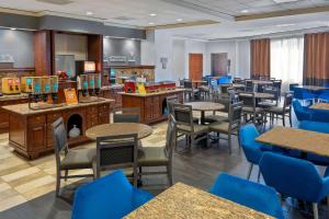 堪萨斯城乡村俱乐部广场汉普顿套房酒店的一间配备有桌子和蓝色椅子的用餐室