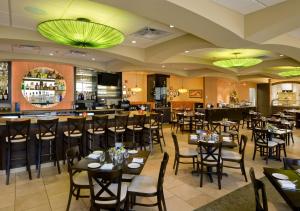 曼凯托曼凯托市中心希尔顿花园酒店的一间带桌椅的餐厅和一间酒吧