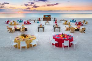 马可岛希尔顿马可岛海滩度假酒店加及Spa的海滩上的餐厅,配有桌椅