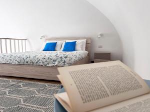 特拉尼TornaRé的一间卧室,配有一张床和一张桌子上的书