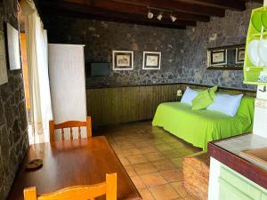 弗龙特拉Estudio Rural de Piedra的一间卧室配有一张绿色的床和一张桌子