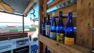 拉克鲁斯Roof Cabin de La Casita Azul的四瓶葡萄酒坐在木墙上