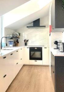 富尔纳斯Penthouse Furnas的厨房配有白色橱柜和黑烤箱。