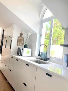 富尔纳斯Penthouse Furnas的白色的厨房设有水槽和窗户