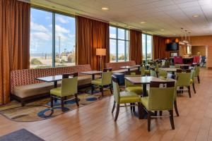 弗吉尼亚海滩弗吉尼亚海滩南海滨汉普顿酒店的用餐室设有桌椅和窗户。